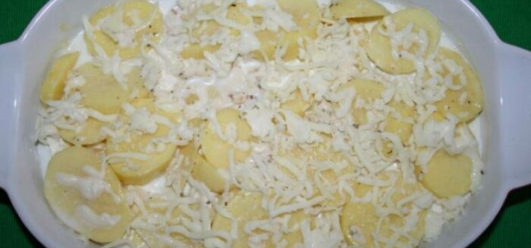 подготовленный картофель нарезать на кружочки и сверху залить смесью сливок и сыра